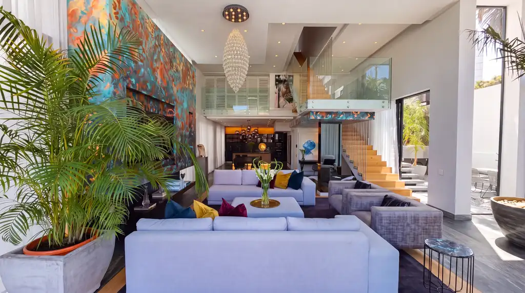 Reconstruction from a photograph: a double-height living room in Bantry Bay, its feature wall painted by Linda Wolf in teal and copper.